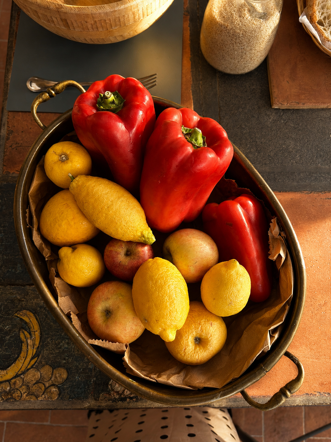 A warmly lit Roman kitchen counter at dusk with lemons, garlic and a glass of wine